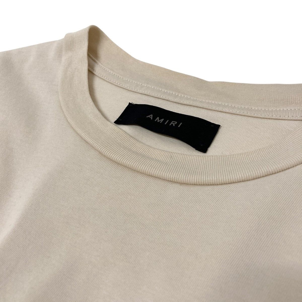 25SS AMIRI ベージュ コットン フロントプリント ロゴ Ｔシャツ AMIRI logo-print Cotton T-shirt | Black | FARFETCH