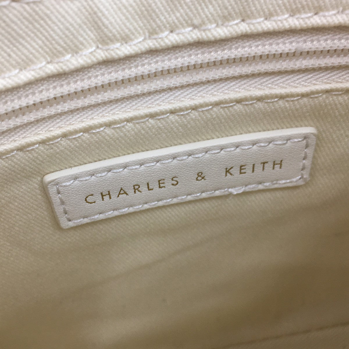 CHARLES ＆ KEITH 古着・中古 チャールズアンドキース)の23AW Cream Lane Lock ＆ Key Chain Handle Trapeze Bag ロック＆キーチェーン ハンドルトラペーズバッグ ショルダーバッグです。